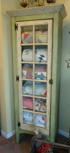 an old cabinet is decorated with quilts and other items for sale on the internet