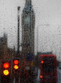 traffic lights are seen through the rain covered window