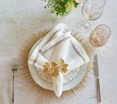 a place setting with napkins, silverware and flowers