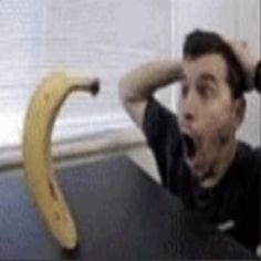 a man sitting at a table with a banana in front of him