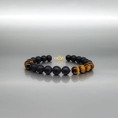 Mens bracelet black onyx Tigers eye gemstone, Jewelry for men, Unique gifts for men - for him The Gnatus black Onyx -Tiger eye bracelet, is for the sophisticated man with good taste. The polished Tiger eye and the black Onyx beads are arranged in asymmetrical order and divided with 14K gold plated elements. Each stone is carefully selected, strung on stainless steel wire for maximum hold and closed with a 14K gold plated Sterling silver clasp. The Bracelet features: ▪️ Genuine Black Onyx polishe Masculine Black Jewelry For Gift, Modern Black Bracelets With Gemstone Beads, Masculine Black Bracelet Jewelry, Modern Onyx Bracelets For Gifts, Modern Onyx Bracelets For Gift, Modern Onyx Bracelets As Gift, Black Agate Bracelets With Natural Stones, Sophisticated Man, Masculine Jewelry