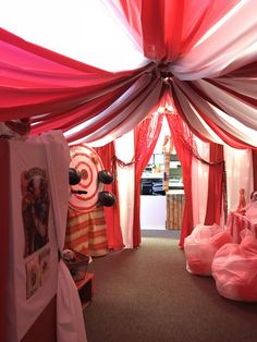 the inside of a tent with red and white drapes on it's walls