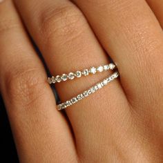 a woman's hand with a diamond ring on top of her finger and the band is