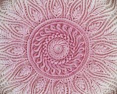 a pink crocheted doily is shown in the shape of a circular flower