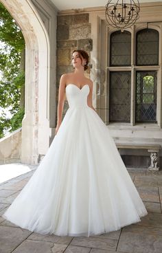 a woman in a wedding dress standing outside