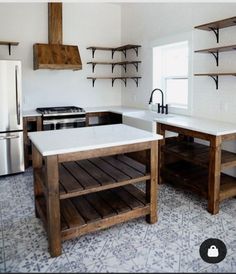 a kitchen with white counter tops and wooden shelves