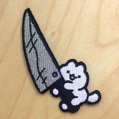 a white and black patch with a cat holding a knife on it's back