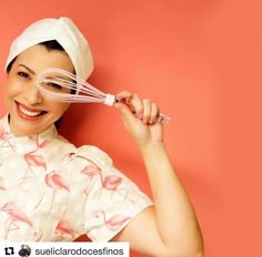 a woman holding a whisk over her head