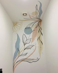 an artistic mural on the side of a wall in a room with white walls and flooring