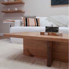 a living room with a white couch and wooden coffee table in front of the sofa