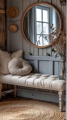 a room with a bench, mirror and vase on the wall