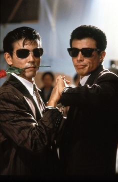 two men in suits and sunglasses standing next to each other