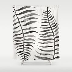 a shower curtain with black and white leaves printed on the front, in an abstract manner