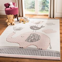 a child's rug with an elephant and birds on it in front of a window