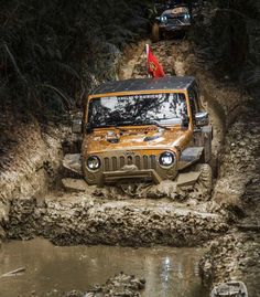 two jeeps driving through mud in the woods