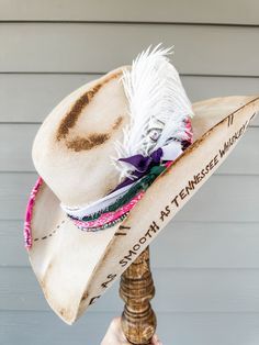 Silverbelly Hand Decorated Wool Cowgirl Hat Additional Information: Will need Head Measurement for hat All feathers and ribbons are glued to hold on to the hat. All hats are decorated, burned, hand-burned/engraved by Annrita Velardi Hat was burned, will have a slight odor at first. Please message us if you would like your hat personalized or have any questions. Branded Cowboy Hats, Curved Brim Hat Bands With Feathers For Western-themed Events, Artisan Hat Bands For Kentucky Derby, Curved Brim Feathered Hat Bands For Rodeo, Artisan Hat Bands For Kentucky Derby Festival, Custom Feather Hat Bands For Country Events, Bohemian Hat Bands With Feather Trim And Flat Brim, Bohemian Hat Bands With Feather Trim, Custom Hats With Feathers For Rodeo