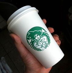 a person holding a starbucks cup in their left hand with the logo dragon on it