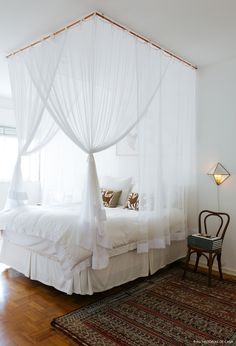 a white bed sitting on top of a wooden floor