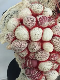 a bunch of red and white balls on top of a black chair with lace around it