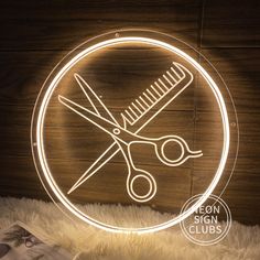 a neon sign with scissors and combs on it in the shape of a circle