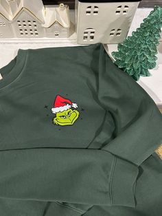 New and trendy hoodie sweatshirt  Siz X L dark green colored sweatshirt printed colored grinch face fabric soft and comf front print and left side of the sweater Grinch Face, Colorful Sweatshirt, Printed Sweatshirts, Hoodie Sweatshirt, Grinch, Looks Great, Soft Fabrics, Dark Green, Sweat Shirt