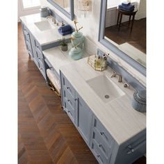 a bathroom vanity with two sinks and mirrors