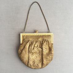 This is a mint example of an edwardian opera purse / hand bag. Fashioned out of a stiff gold brocade, Lined in an ivory cotton Attached to a gold coloured metal fame that clicks closed , held by a fine gold coloured chain. Inside is one patch pocket , which holds the original mirror.  A tiny little decorative bag big enough for your lipstick and handkerchief. Please buy this dazzling bag and take it to the opera. Supplied in a gift box Classic Gold Shoulder Bag For Evening, Classic Yellow Gold Formal Bag, Classic Formal Yellow Gold Bag, Classic Yellow Gold Formal Bags, Elegant Yellow Gold Evening Bag, Vintage Gold Shoulder Bag For Party, Cream Evening Bag With Detachable Handle, Formal Yellow Gold Bags With Detachable Handle, Elegant Yellow Gold Evening Shoulder Bag