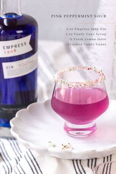 pink peppermint sour cocktail in a glass with sprinkles on the rim