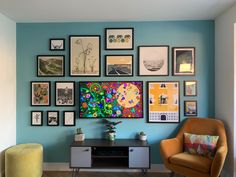 a living room filled with furniture and framed pictures on the wall above a tv unit