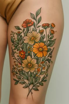 a woman's thigh with flowers and leaves on it