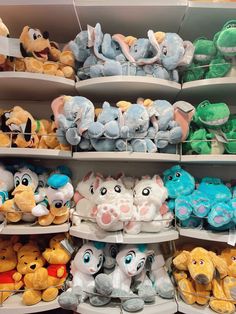 many stuffed animals are on shelves in a store