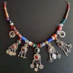 Beautiful unique Berber necklace made up of a string of many different colorful vintage glass and metal beads separating 5 older metal amulet pendants decorated with colored glass centerpieces and two older traditional shawl clips. Amulets derive from older traditional decorative Berber women headdresses. *PLEASE NOTE THAT YOUR PHONE NUMBER IS REQUIRED SEPARATELY TO INITIATE SHIPPING* Amulet Style Jewelry With Large Beads For Festivals, Eclectic Silver Jewelry For Festivals, Traditional Large Bead Dangle Jewelry, Traditional Large Beaded Dangle Necklaces, Traditional Large Beads Dangle Jewelry, One Of A Kind Multicolor Amulet Beaded Necklaces, Traditional Dangle Jewelry With Large Beads, Vintage Multicolor Jewelry For Rituals, One Of A Kind Multicolor Eclectic Jewelry