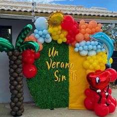 balloon decorations are displayed on the side of a building with palm trees and balloons attached to it