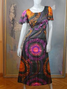 This 1970s mod dress has a stunningly vibrant purple, pink, and orange effervescent abstract polka dot pattern on a black satin sheen background. The dress has a round neckline and short sheer puff sleeves, and a fitted waistline with a matching belt gives way to an A-line drop to the midi-length hemline. The dress is lined in a black satin viscose-nylon fabric, and closes in the back with an 18.5-inch zipper. Bust = 40 inches (101cm) Shoulders = 16.5 inches (41.91cm) Waist = 32 inches (81.28cm) Fitted Mod Dress With Vintage Print, Mod Fitted Dress With Vintage Print, Retro Colorful Dresses With Vibrant Print, Retro Dresses With Vibrant Print, Colorful Retro Dresses With Vibrant Print, Multicolor Vintage Print Dress, Fitted Purple A-line Maxi Dress, Multicolor Vintage Print Short Sleeve Dress, Multicolor Short Sleeve Dress With Vintage Print