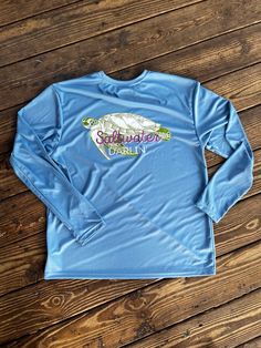 Our long sleeve fishing shirts are not only comfy but cooling for those hot summer days. Our fishing shirt offers 44+ UPF for sun protection too!  What better way to stay safe and cool in the sun while you look cute too?!? Front Saltwater Darlin logo and back design on light blue long sleeve. These designs are my own original design transferred to tee and hold up excellently!  100% polyester unless otherwise noted. Stain release and odor resistant. Moisture wicking too!  Care instructions:  Wash Women Fishing Shirt, Summer Fishing T-shirt With Crew Neck, Fishing Long Sleeve Shirts, Graphic Tee T-shirt For Fishing, Graphic Tee Short Sleeve T-shirt For Fishing, Fishing Women, Hold Ups, Fishing Shirts, Hot Summer