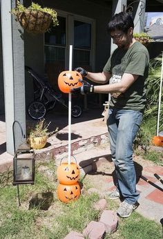 a man is decorating pumpkins in the yard