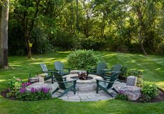 an outdoor fire pit surrounded by lawn chairs