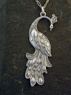 "This Peacock Bird pendant is Sterling Silver. The included chain is a Sterling Silver Figaro 50 chain. You may choose 16, 18 or 20 inch at the same price. Other length available at sightly higher prices. This Peacock Bird pendant measures 2 3/8\" tall by 7/8\" across. I hand cast all my pieces using the lost wax casting method. Please ask your needs. You may call me with questions, often I am out so please use my machine. 831-476-3176. Satisfaction Guaranteed! I send items USPS First Class unle Silver Metal Necklace With Peacock Design, Elegant Peacock Pendant Necklace, Elegant Peacock Color Pendant Necklace, Sterling Silver Necklace With Peacock Design, Silver Peacock Pendant Necklace, Elegant Silver Necklace With Peacock Design, Ornate Peacock Design Necklace For Gift, Peacock Design Pendant Necklace Gift, Peacock Design Pendant Necklace As Gift