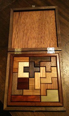 a wooden box that has some sort of puzzle inside of it on a wood table