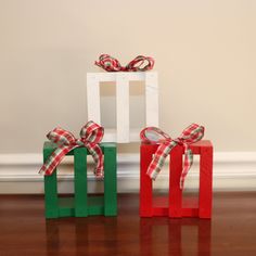 two wooden blocks with bows on them sitting on the floor in front of a wall