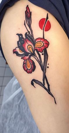 a woman's thigh with flowers on it and a red dot in the background