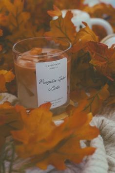 a candle sitting on top of a pile of leaves