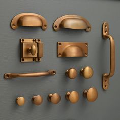 an assortment of door handles and knobs on a gray surface with gold colored hardware