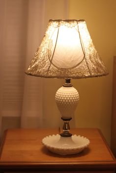 a white lamp on top of a wooden table