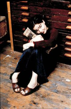 a woman sitting on the floor reading a book