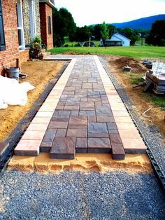 a brick walkway being built in front of a house