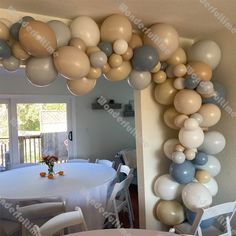 an arch made out of balloons in the shape of a heart on a dining room table