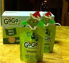 three bags of gogo squeez are sitting on a table next to an apple box