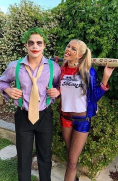 two people dressed up as the joker and harley are posing in front of a hedge