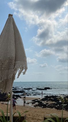 an umbrella on the beach with people in the background